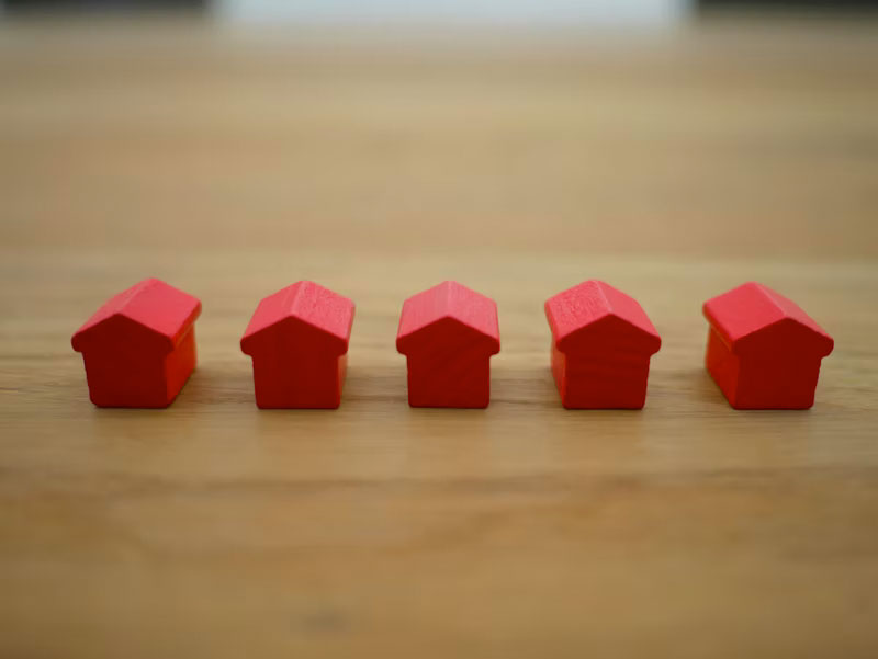 red houses from monopoly on a wooden table